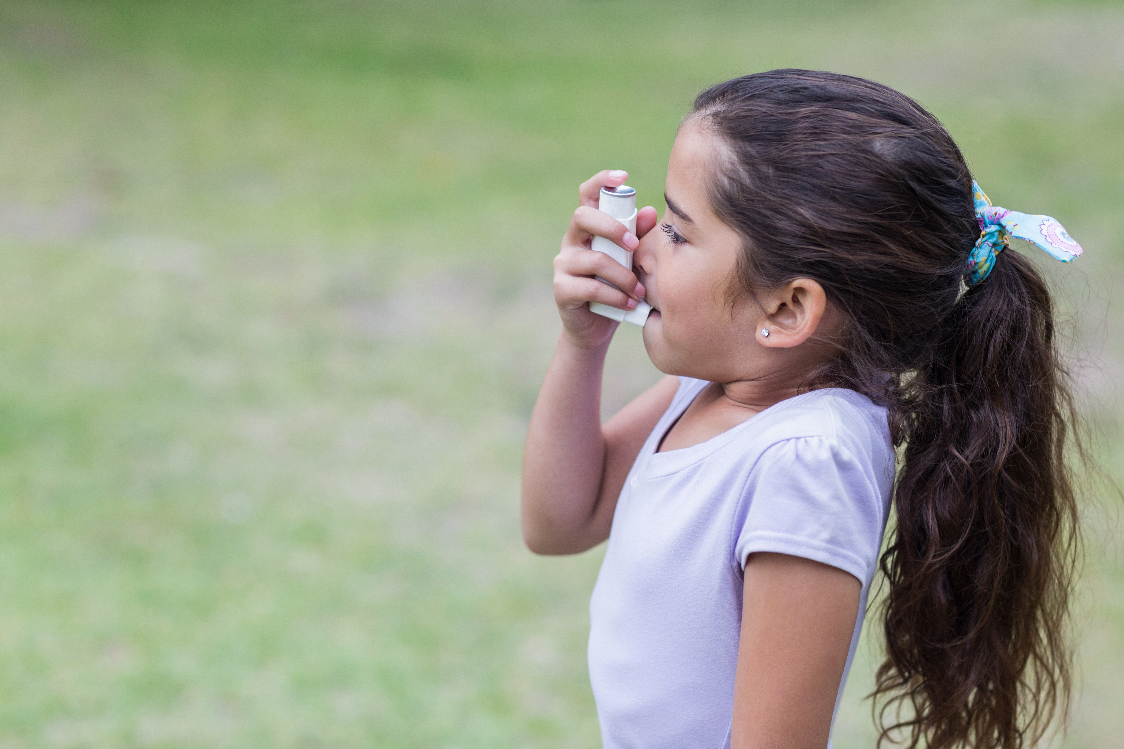 Little girl using his inhaler